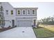 Modern two-story townhome with gray siding, two-car garage, and landscaped lawn at 221 Admor Ln, Acworth, GA 30102