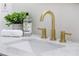 White quartz countertop with gold faucet and a white sink at 5375 Ashwind Trce, Alpharetta, GA 30005