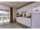 Small, well-equipped kitchen in the basement with white cabinets and lake views at 1126 Wedgefield Dr, Marietta, GA 30064