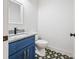 Small bathroom with blue vanity, granite countertop, and patterned floor at 2127 Nichols Ln, Decatur, GA 30032