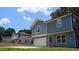 Two-story home with gray siding, white garage door, and landscaped yard at 1351 E Atlanta E Rd, Stockbridge, GA 30281