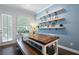 Cozy dining area featuring a rustic wooden table, floating shelves, and natural light from a nearby door and window at 290 Walker Ave, Alpharetta, GA 30076