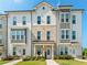 Three-story townhome with light-colored brick and siding, welcoming porch, and landscaping at 110 Cobalt Dr, Fayetteville, GA 30214