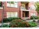 Brick building with balconies, lush landscaping, and a walkway at 273 12Th Ne St # 114, Atlanta, GA 30309