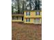 Cute yellow house with green shutters, a two-car garage, and a yard at 701 Boone Ct, Stone Mountain, GA 30088