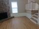Light and bright living room with wood-look floors, a stone fireplace, and a staircase at 701 Boone Ct, Stone Mountain, GA 30088