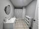 Clean bathroom features a sink, toilet, shower, and storage shelves for toiletries and essentials at 4908 Topsfield Ln, Lithonia, GA 30038