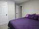 Bedroom featuring a bed with a purple comforter and two white doors at 4908 Topsfield Ln, Lithonia, GA 30038