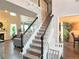 Staircase with white railings and black handrails leading to the second floor at 4908 Topsfield Ln, Lithonia, GA 30038