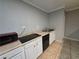 Kitchen area with an electric stovetop, microwave, dishwasher, and white cabinets, complete with tile flooring at 4908 Topsfield Ln, Lithonia, GA 30038