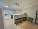 Kitchenette with white cabinets, tile flooring, a breakfast bar with stools, and modern appliances at 4908 Topsfield Ln, Lithonia, GA 30038