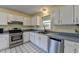 Kitchen with stainless steel appliances and white cabinets at 5762 Lilburn Stone Mountain Rd, Stone Mountain, GA 30087