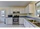 Kitchen with stainless steel appliances and white cabinets at 5762 Lilburn Stone Mountain Rd, Stone Mountain, GA 30087