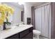 Clean bathroom with dark vanity, white toilet, and grey shower curtain at 3948 Lake Manor Way, Atlanta, GA 30349