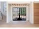 Bright entryway with hardwood floors, large black framed doors, and curved staircase at 1890 W Paces Ferry Nw Rd, Atlanta, GA 30327