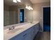 Bathroom with double vanity, large mirror, and modern light fixture at 8255 Stonebrook Dr, Cumming, GA 30040