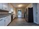 Kitchen with stainless steel appliances, white cabinets, a view to the dining room and dark countertops at 8255 Stonebrook Dr, Cumming, GA 30040