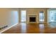 Bright living room with hardwood floors, a fireplace and two windows facing the exterior of the house at 8255 Stonebrook Dr, Cumming, GA 30040