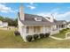 A view of the front yard with a covered porch, small bushes, and green grass at 4811 Westgate Blvd, Atlanta, GA 30349