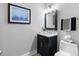 Clean bathroom with dark vanity, a toilet, and a framed print at 135 River Point Ct, Alpharetta, GA 30022