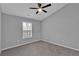 A bedroom featuring a ceiling fan, neutral paint, carpet, and natural light from a window at 593 Woodland Park Ter, Lawrenceville, GA 30043