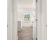 Hallway view of tiled bathroom with double sinks and wood look floors at 989 Blue Juniper Cir, Loganville, GA 30052