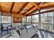 Relaxing screened porch with gray couch, wooden ceiling beams, and large windows at 310 Medridge Dr, Johns Creek, GA 30022