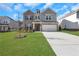 Two-story brick home with gray siding, a two-car garage, and a landscaped lawn at 3069 Shirecrest Lane, Dacula, GA 30019