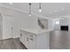 Kitchen island with white cabinets and quartz countertop, open to living area at 3069 Shirecrest Ln, Dacula, GA 30019