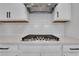 Gas cooktop and white hexagonal backsplash in modern kitchen at 3069 Shirecrest Ln, Dacula, GA 30019