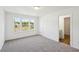 Bright bedroom featuring neutral carpeting, a window view, and an adjoining bathroom at 7268 Eton Ln, Locust Grove, GA 30248