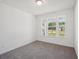 Cozy bedroom with a view through large windows, neutral carpet, and a ceiling light fixture at 7268 Eton Ln, Locust Grove, GA 30248