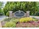 Elegant stone sign for Heron Bay Golf & Country Club surrounded by colorful flowers at 7268 Eton Ln, Locust Grove, GA 30248