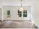 Dining area showcases a modern chandelier, wood-look flooring and sliding glass door to deck at 7268 Eton Ln, Locust Grove, GA 30248