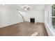 Bright living room features modern hardwood flooring, fireplace, and lots of light from several windows at 7268 Eton Ln, Locust Grove, GA 30248