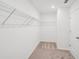 Spacious walk-in closet featuring neutral carpeting and ample shelving for optimal storage space at 7268 Eton Ln, Locust Grove, GA 30248