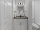 Small bathroom with granite countertop and white vanity at 9404 Cypress Ln, Jonesboro, GA 30238