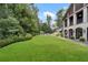 Expansive backyard with a well-maintained lawn, mature trees, and a glimpse of the home's architectural features at 3612 Castlegate Nw Dr, Atlanta, GA 30327