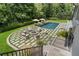 Inviting backyard featuring a sparkling pool, comfortable lounge chairs, and a cozy fire pit area surrounded by lush landscaping at 3612 Castlegate Nw Dr, Atlanta, GA 30327