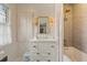 Well-lit bathroom featuring a vanity, patterned wallpaper, and a tub-shower combo with tile surround at 3612 Castlegate Nw Dr, Atlanta, GA 30327