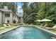 Backyard features a large pool, water fountains, lounge chairs, and manicured landscaping at 3612 Castlegate Nw Dr, Atlanta, GA 30327