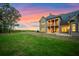 Expansive backyard with lush green grass and an elegant brick home in the distance at sunset at 4927 Slaton Drive, Acworth, GA 30101