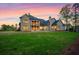 Expansive backyard at dusk features a lush lawn and a large brick home with a covered porch at 4927 Slaton Drive, Acworth, GA 30101