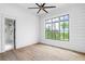 Bright bedroom features hardwood floors, a modern fan, and a large window with scenic views at 4927 Slaton Drive, Acworth, GA 30101