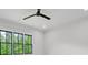 Bright bedroom with a ceiling fan, white walls, and large black-framed windows overlooking lush greenery at 4927 Slaton Drive, Acworth, GA 30101