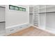 Bright walk-in closet boasts custom shelving and built-in storage, complemented by a sunlit window for added elegance at 4927 Slaton Drive, Acworth, GA 30101