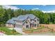 Stunning two-story brick home with manicured landscaping, a stone retaining wall, and a circular driveway at 4927 Slaton Drive, Acworth, GA 30101