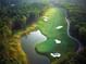 Scenic aerial view of a golf course with a water hazard, sand traps, and lush green fairways at 4927 Slaton Drive, Acworth, GA 30101