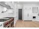 Modern kitchen boasts stainless steel appliances, white cabinetry, and light hardwood floors at 4927 Slaton Drive, Acworth, GA 30101