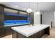 Spacious kitchen with large island and dark wood cabinets, with modern pendant lighting and blue LEDs at 4927 Slaton Drive, Acworth, GA 30101
